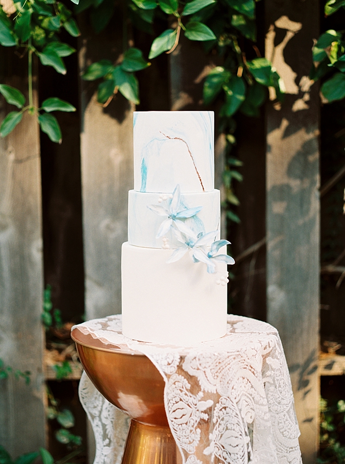 White and blue marble wedding cake with floral details | Photo by Dennis Roy Coronel | See more on thesocalbride.com