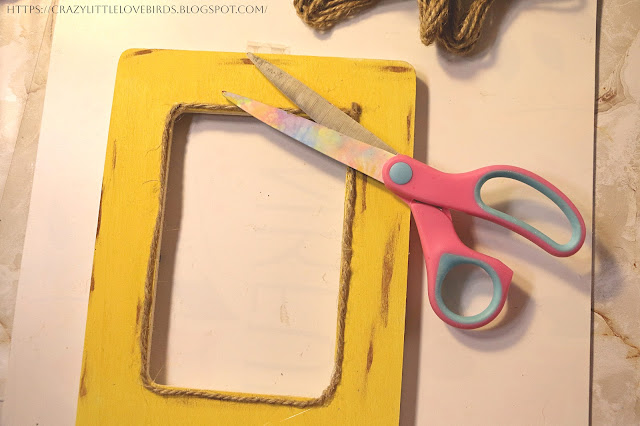 Yellow frame with twine and scissors on a table