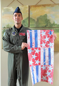 photo of: Captain Mettle displays Kindergarten Artwork inspired by "Red, White and Blue" picture book