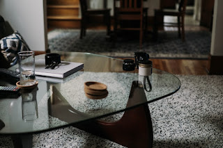 A living room coffee table covered with items