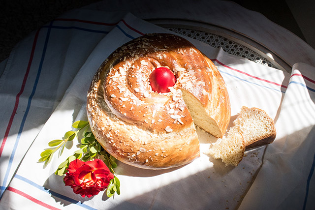 Tsoureki, Greek Easter bread with red egg on a white table cloth