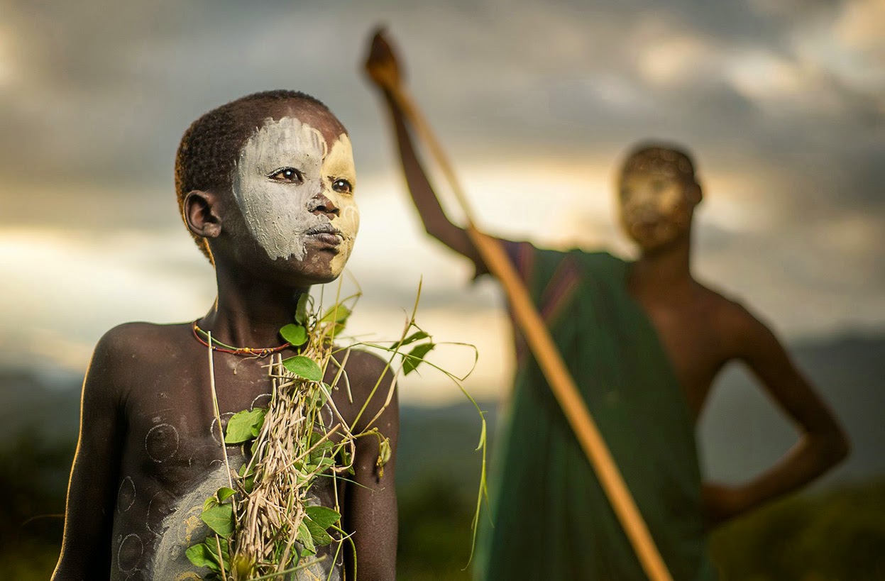 A BOY OF THE NOMADIC SURI TRIBE OF ETHIOPIA, IN TRADITIONAL FACE/BODY PAINT AND ATTIRE - 29 Breathtaking Photographs of The Human Race