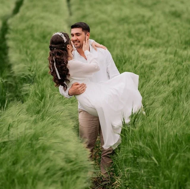 Handsome bearded man princess carries a lovely woman in all white