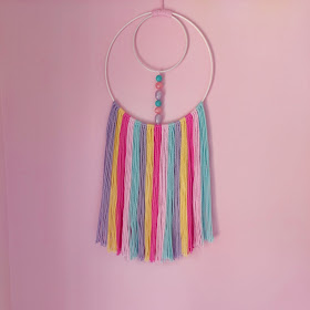 Colourful yarn hoop wall hanging for a baby's nursery