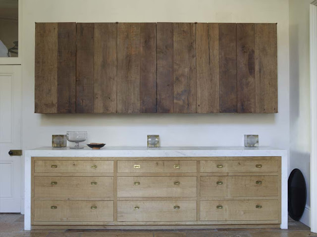 raw wood upper cabinets mixed with blonde wood lowers with antique library drawer pulls and a marble counter surround