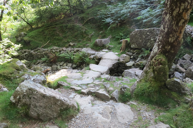 A small, stone bridge crossing a stream.