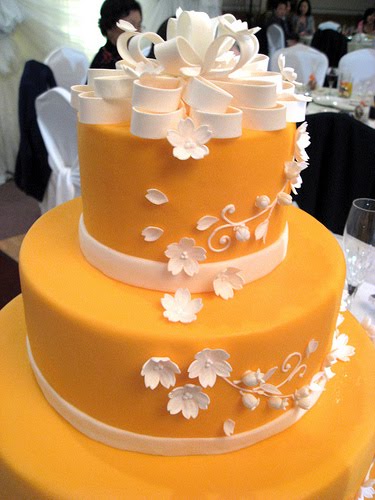 Bold orange wedding cake with white flowers
