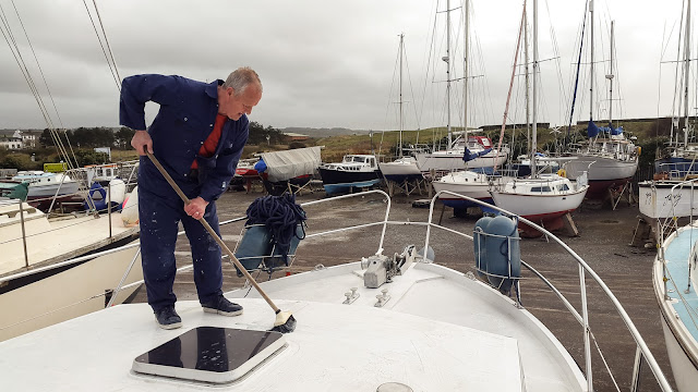 Photo of Phil scrubbing the fore deck