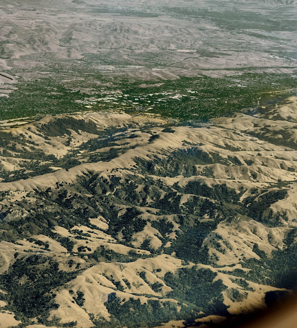 An aerial photo taken somewhere over the US - notice the sandy coloured mountains and small bits of greenspace?