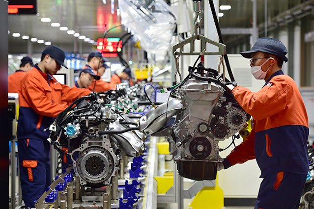 A photograph taken on February 7 captures workers in Yiwu, Zhejiang province, at Zhejiang Geely Holding Group's car production line, diligently assembling engines.