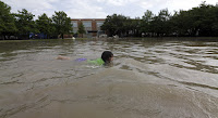 Joselyn Ramirez swims in a flooded school playground in Houston, May 26, 2015, following severe storms. (Credit: AP Photo/David J. Phillip) Click to Enlarge.