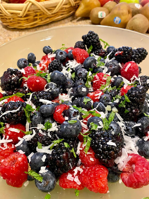 berry salad with mint and coconut shavings