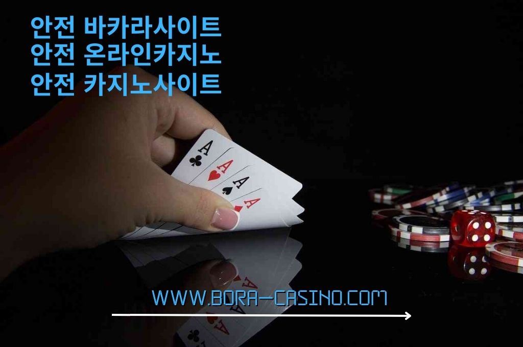 Woman hand holding a four aces cards and all the casino chips and one red dice on the side inside the dark room