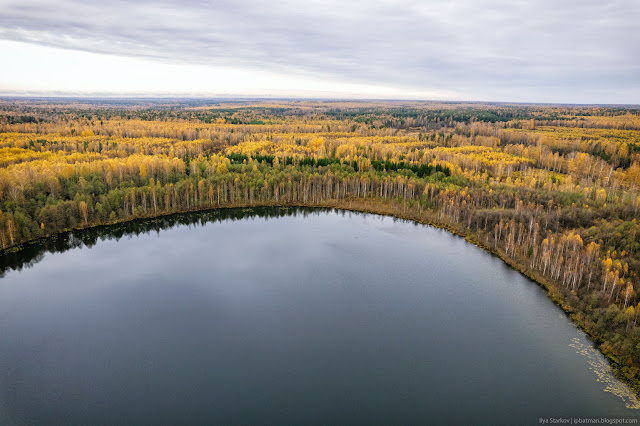 Гладь озера и бескрайние осенние леса