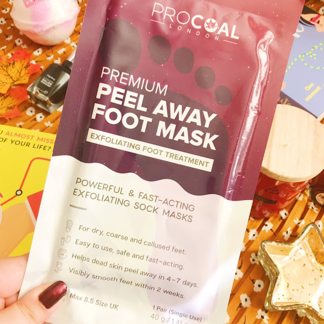 procoal premium foot mask held up above autumnal flatlay