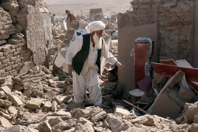 On October 8, 2023, in the Herat province of Afghanistan, an individual is seen engaged in post-earthquake cleanup efforts in the Zenda Jan district, as captured by the Associated Press (AP).