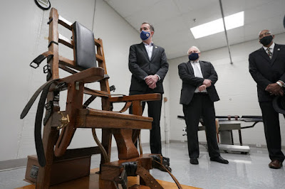 Virginia Gov. Ralph Northam (left) looks over the electric chair in the death chamber at the Greensville Correctional Center.