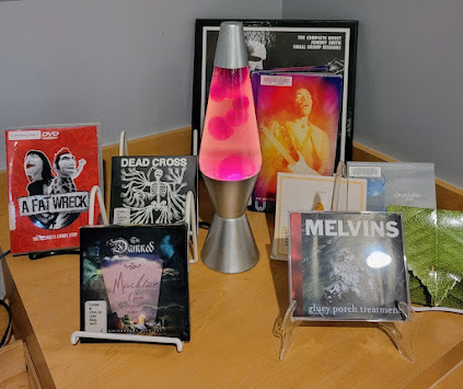 An image of our lava lamp surrounded by a variety of CD, vinyl, and DVD recordings.