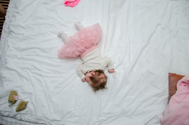 A baby asleep on a bed