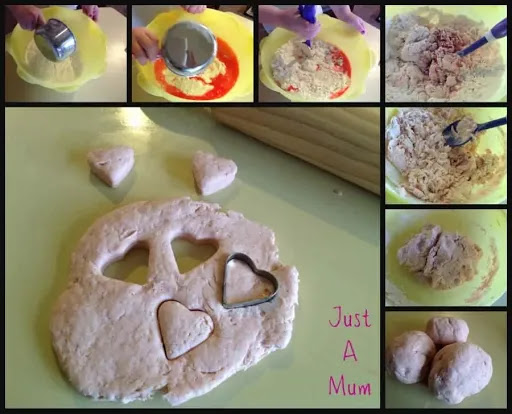 pinkish playdough on table with heart shaped cookie cutters next to the playdough