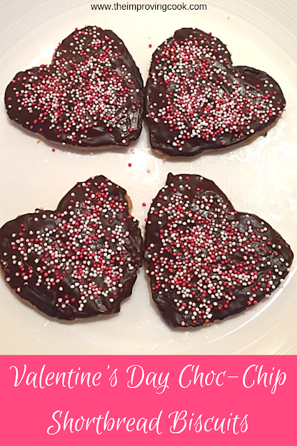 Heart shaped chocolate covered biscuits on a white plate.