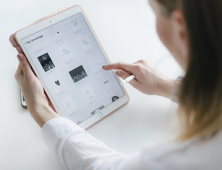 mujer-sentada-junto-a-la-mesa-mientras-usa-el-i-pad