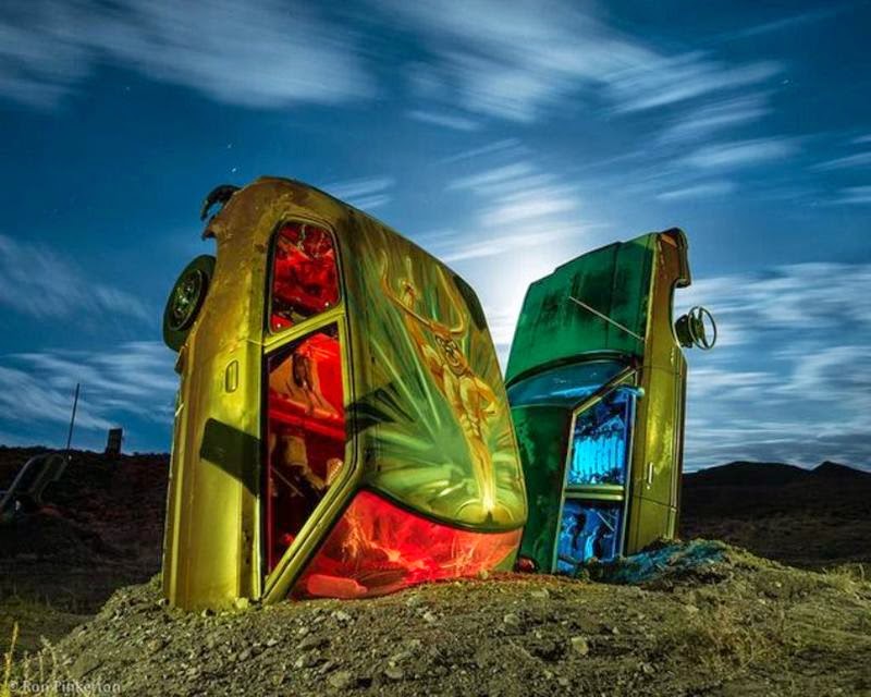 At the edge of Goldfield, a small town in the middle of Nevada, multiple cars, buses, vans, and limos are buried vertically in the desert as if they are growing out of the ground.