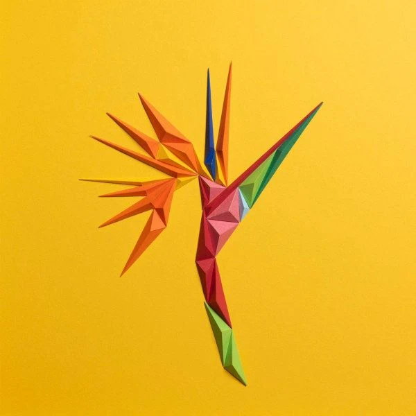 vivid bird of paradise flower composed of folded paper triangles on yellow background