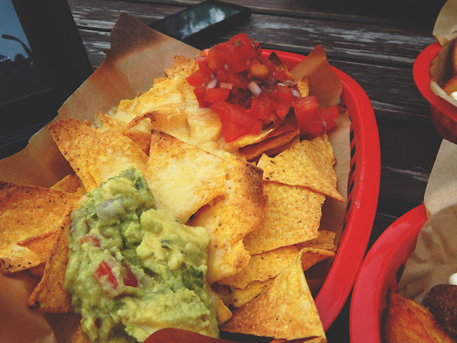 guacamole, cheese, and salsa on top of tortilla chips