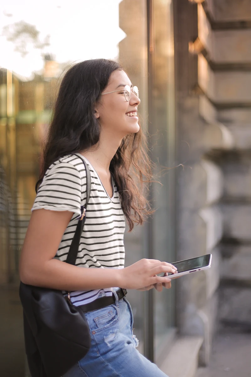 cheerful woman with a book in her hands smiling to the camera