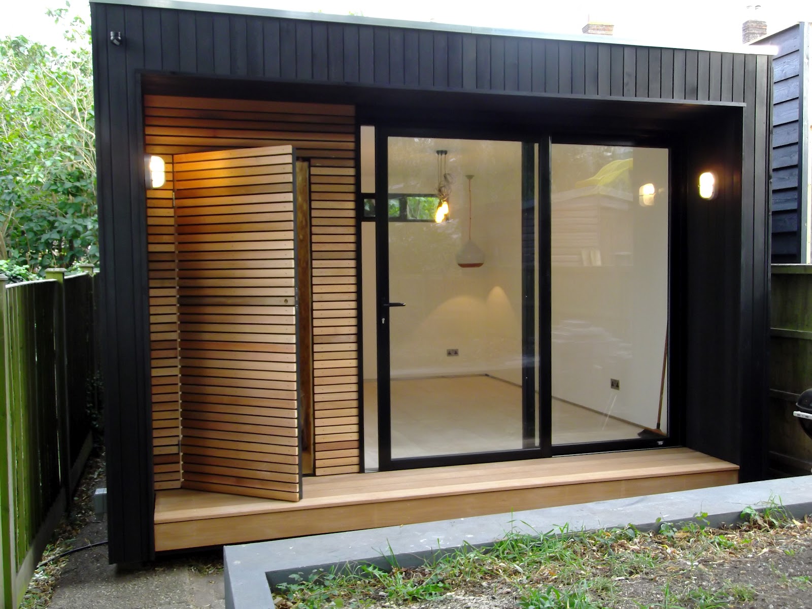 Small Garden Office with sliding doors in black aluminium and bike 