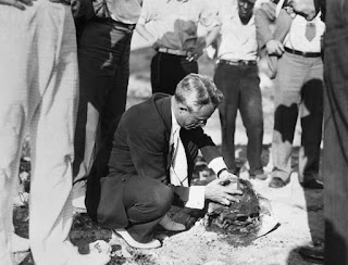 Cleveland Torso murder crime scene photo, an investigator holds a recently discovered severed head