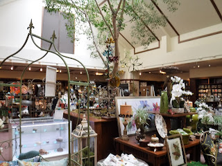 souvenirs of all kinds, most embellished with floral patterns, adorn a well lit gift shop at Lauritzen Gardens