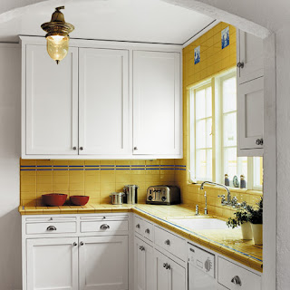 small classic kitchen with yellow tiles and white wooden cabinets