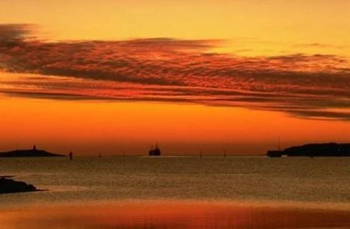 Barco navegando ao entardecer.