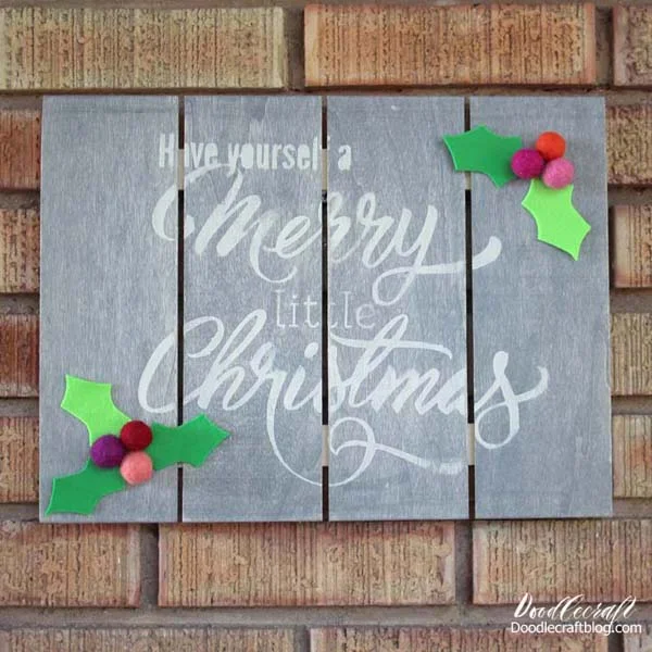 Make a cute holiday sign with acrylic craft paint, pallet wood and felt Holly Berry balls and leaves