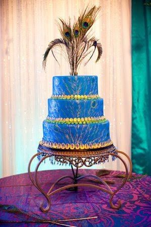 Three tier white round wedding cake with a blue peacock topper who 39s sugar