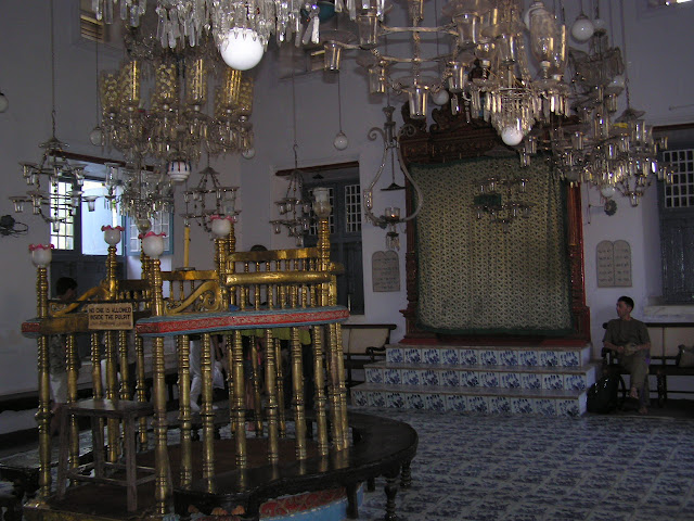 An inside view of the Jewish synagogue in Cochin (Paradesi Synagogue) in Kerala, India, with a person sitting near the pulpit