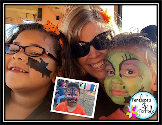 A girl with a bat painted on her cheek, a younger girl with face painting to resemble a witch, and a boy with his face painted to resember a jack o lantern