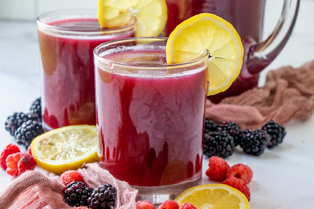 Two glasses with pitcher and berries and lemon