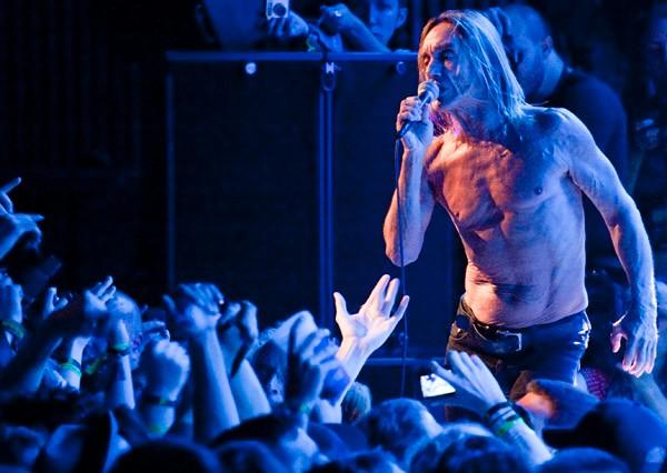  the stage comes a sprinting and shirtless Iggy Pop in skintight pants