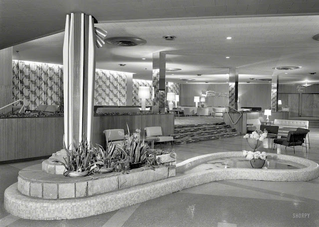 a 1957 hotel lobby with island and pond, and rock stairs