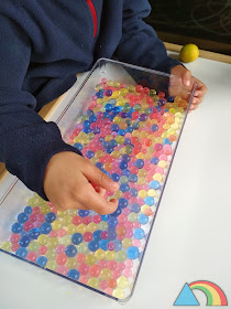 Niño manipulando bolas de gel o water beads de colores.