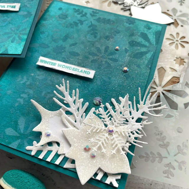 Winter Wonderland Holiday Cards made with: Tim Holtz modern festive die, rock candy distress glitter, distress spray stain, distress oxide, distress mica stain; Scrapbook.com solar white cardstock, wordfetti fa la la stamp, peppermint winter stencil, cools jewels smooth cardstock; Pinkfresh jewels; Pima watercolor paper