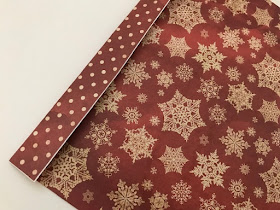 Gluing Christmas paper together to make a gift bag