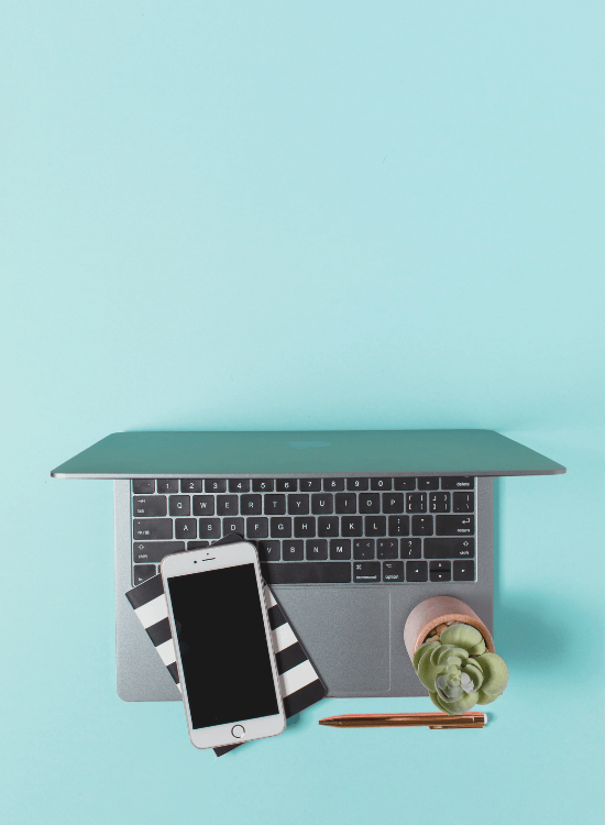 flatlay with laptop, phone, and decorations on aqua background | The Occasional Genealogist