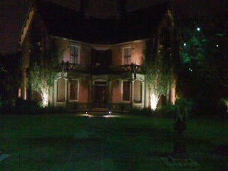 A view in front of a Saint Charles Avenue Mansion Lit Up at Night (exterior)