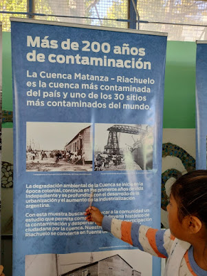 Foto 4: alumna observando uno de los banners de la muestra