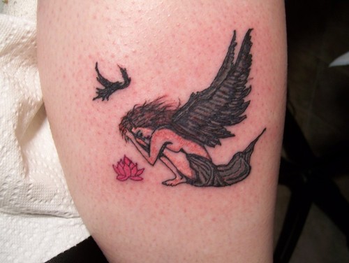 Grieving angel with flower tattoo.