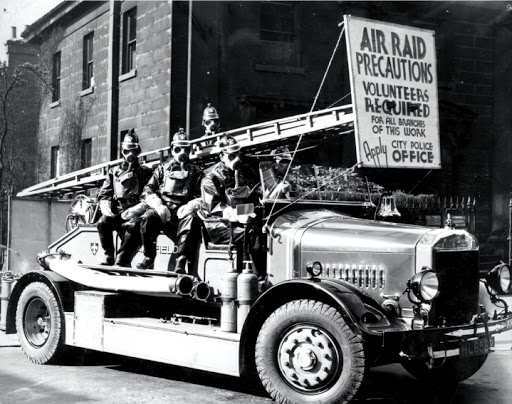 The Dennis Fire Engine being used by the City of Wakefield fire brigade. The firefighters are in full protective equipment of the time, including gas masks.